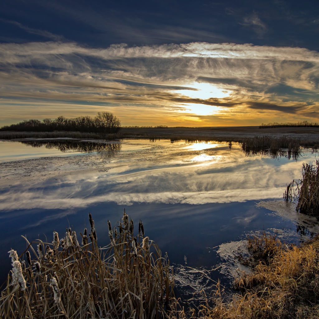 Белые облака отражаются в воде на закате солнца
