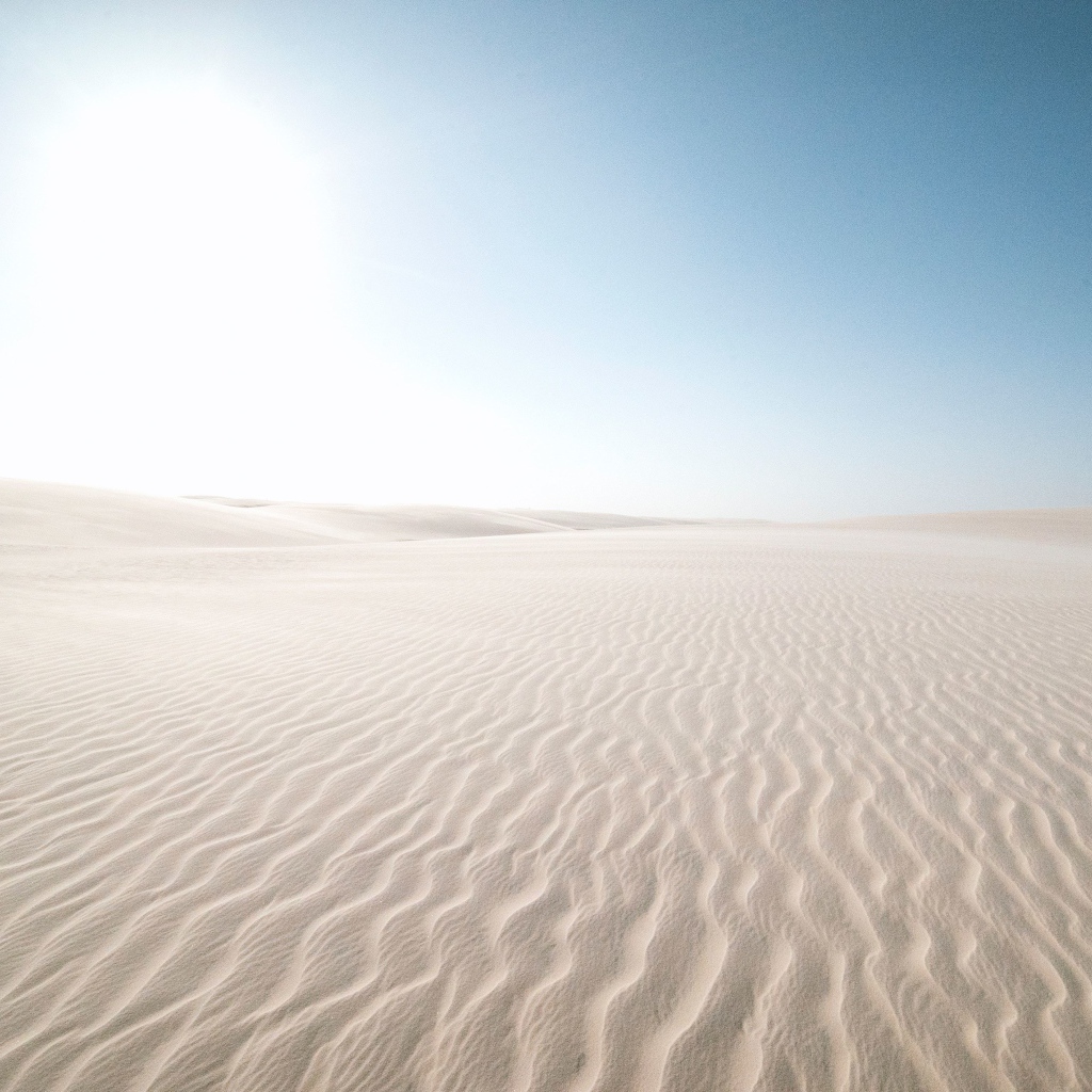 Белый песок в пустыне на фоне голубого неба