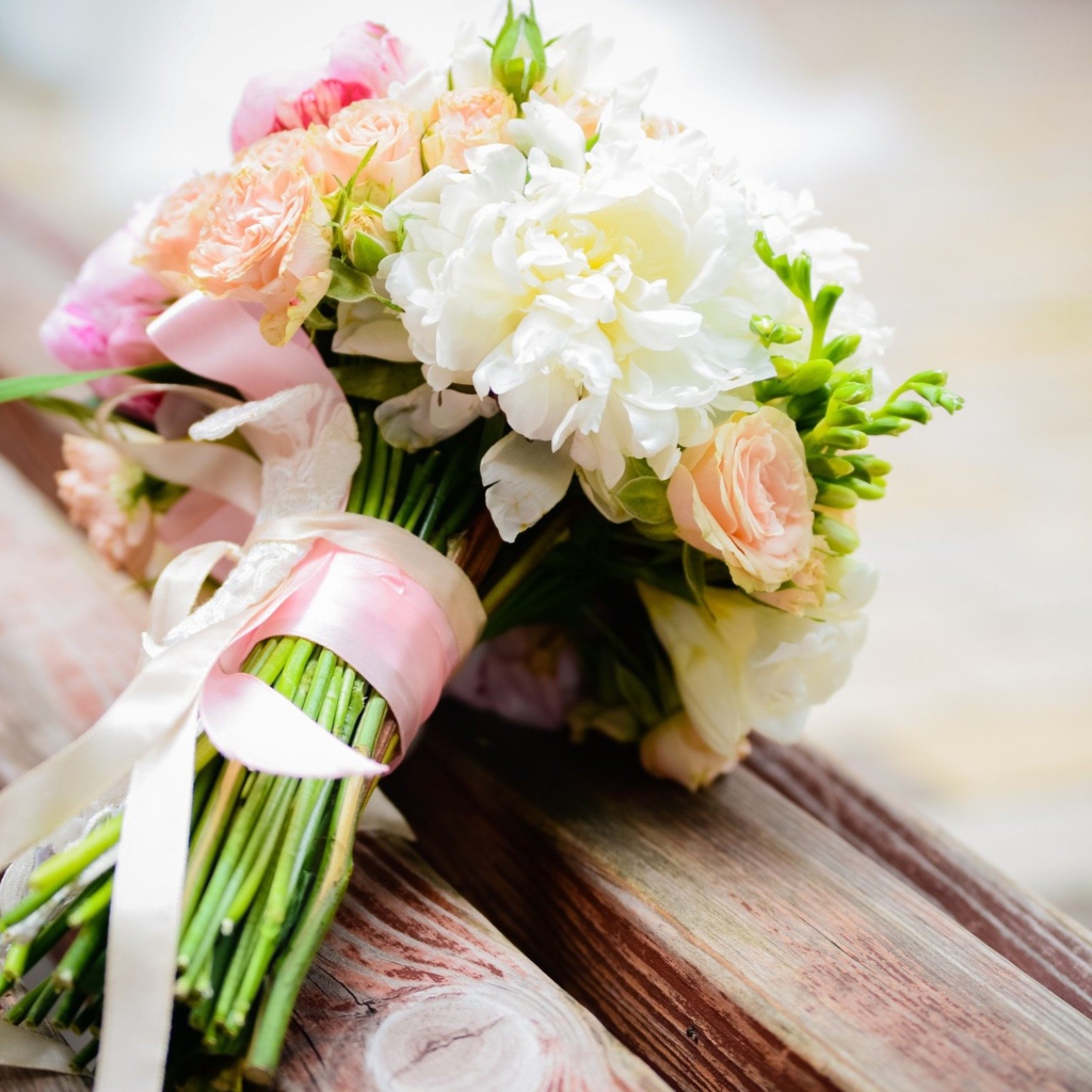 Красивый свадебный букет лежит на деревянной лавке