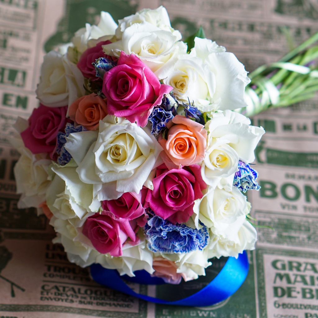 Красивый свадебный букет из роз лежит на газете