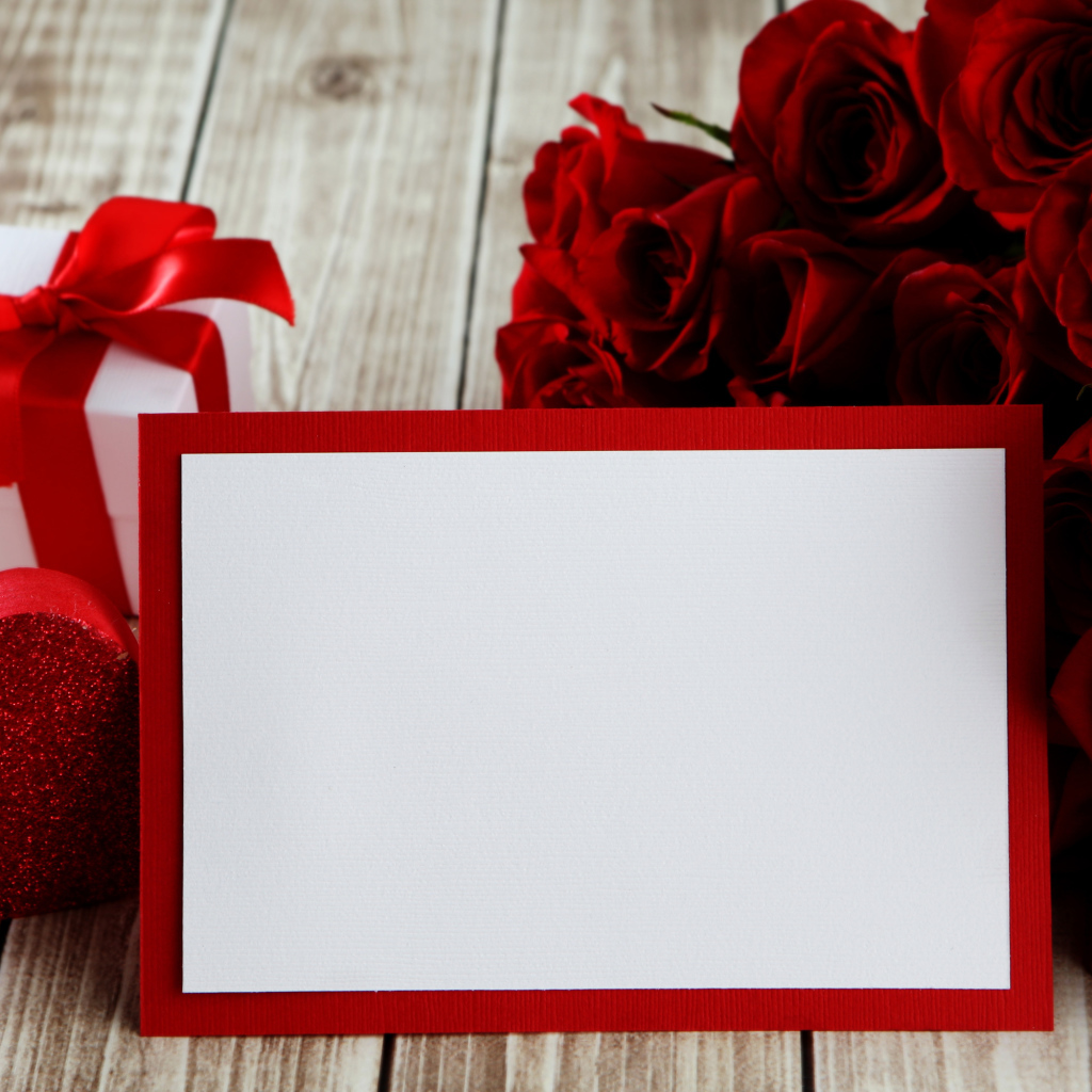 Букет красных роз на столе с подарком и красным сердцем, шаблон поздравительной открытки