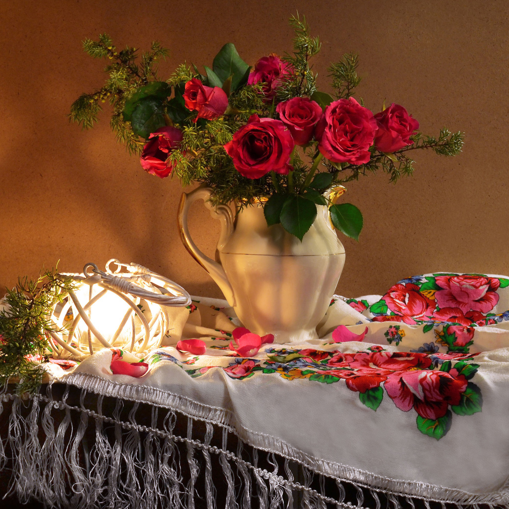 Букет роз в вазе на столе  с красивой скатертью 