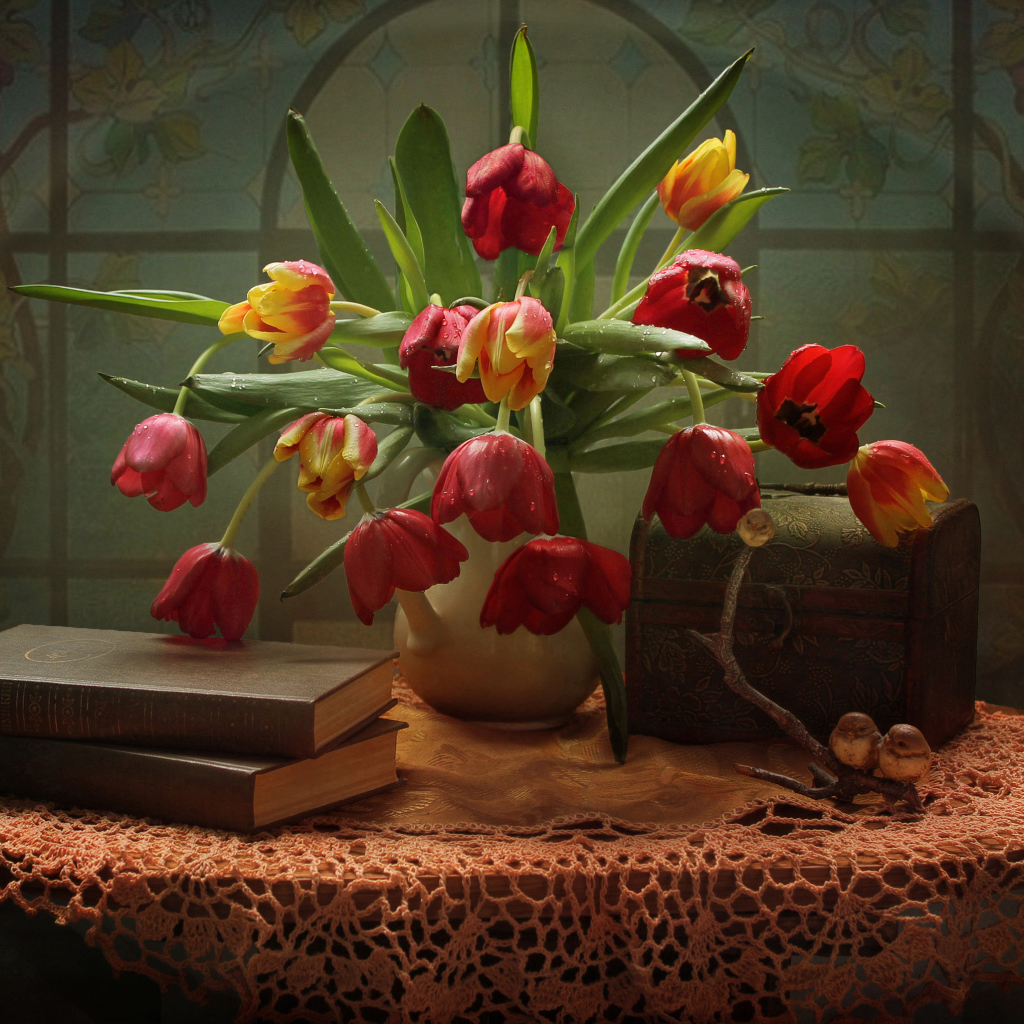 Букет тюльпанов на столе с книгами и шкатулкой