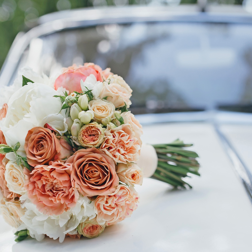 Свадебный букет роз лежит на машине