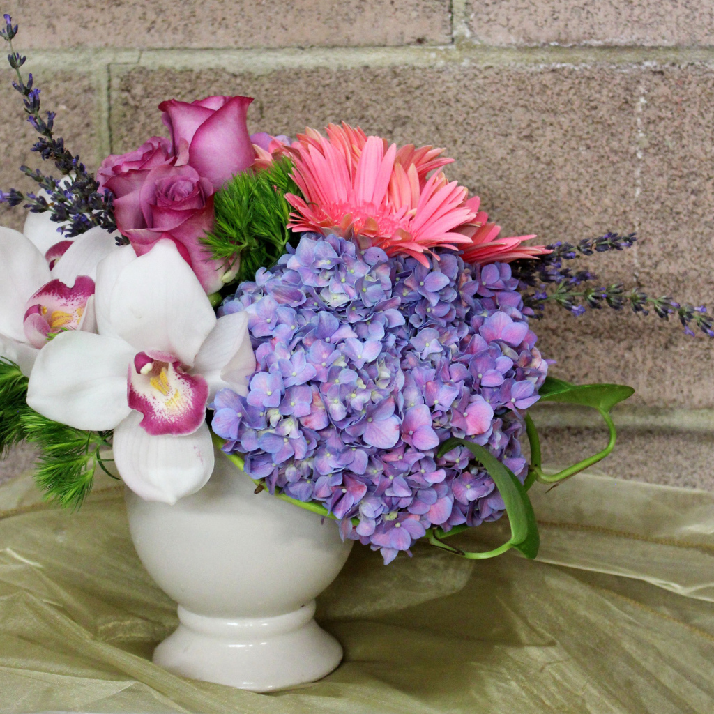 Красивый букет в белой вазе на фоне стены 