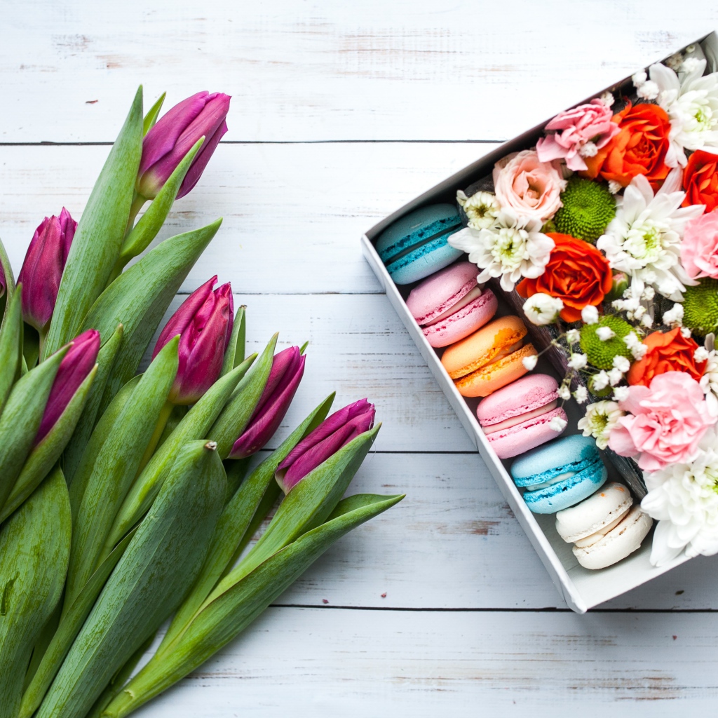 Букет сиреневых тюльпанов на столе с коробкой с макарунами