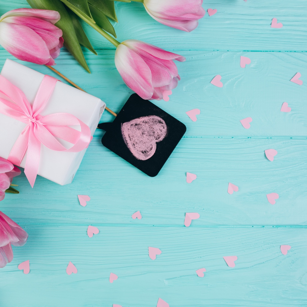 Букет розовых тюльпанов и подарок на голубом фоне