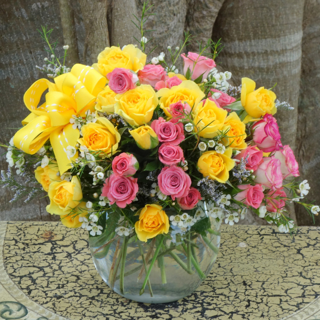 Букет желтых и розовых роз в стеклянной вазе