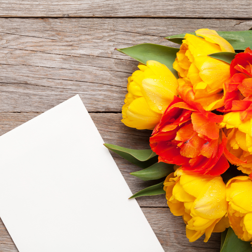 Букет желтых тюльпанов на столе с листом бумаги