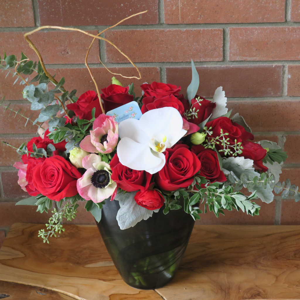 Букет с цветами анемоны, розы и орхидеи у стены 