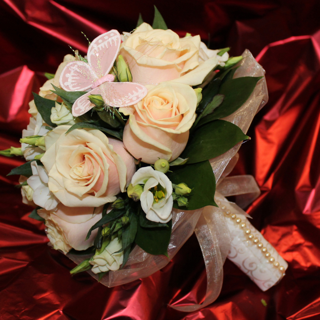 Нежный свадебный букет с цветами розовой розы и эустомы на красном фоне
