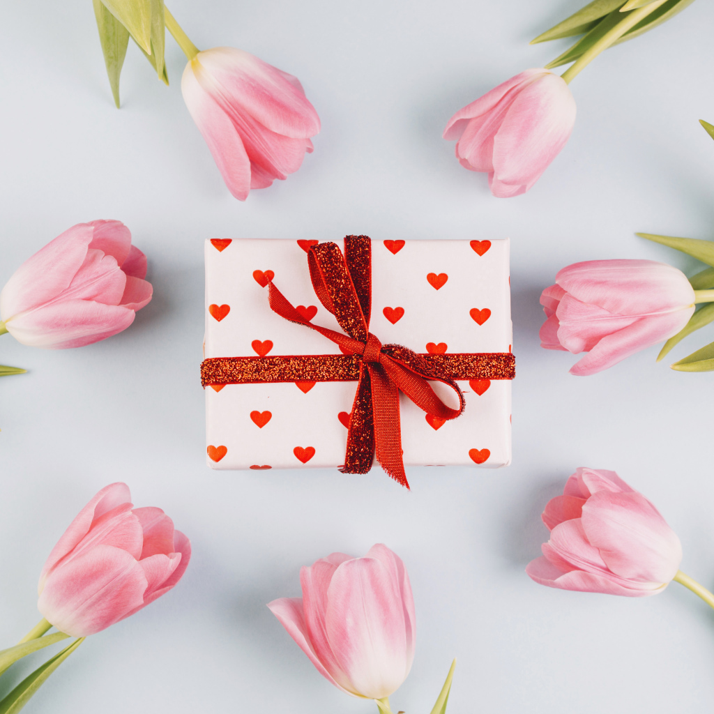 Подарок с розовыми тюльпанами на сером фоне 