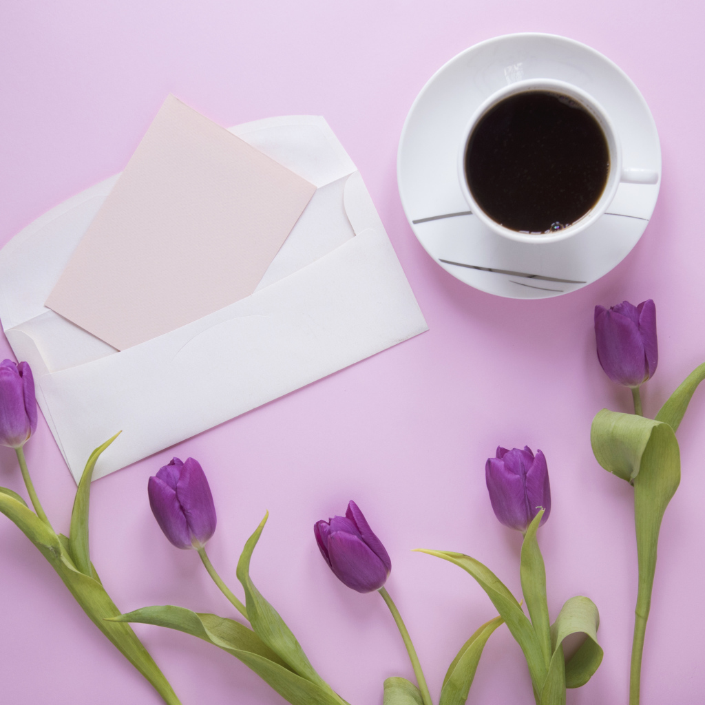 Сиреневые тюльпаны с письмом и чашкой кофе на столе 