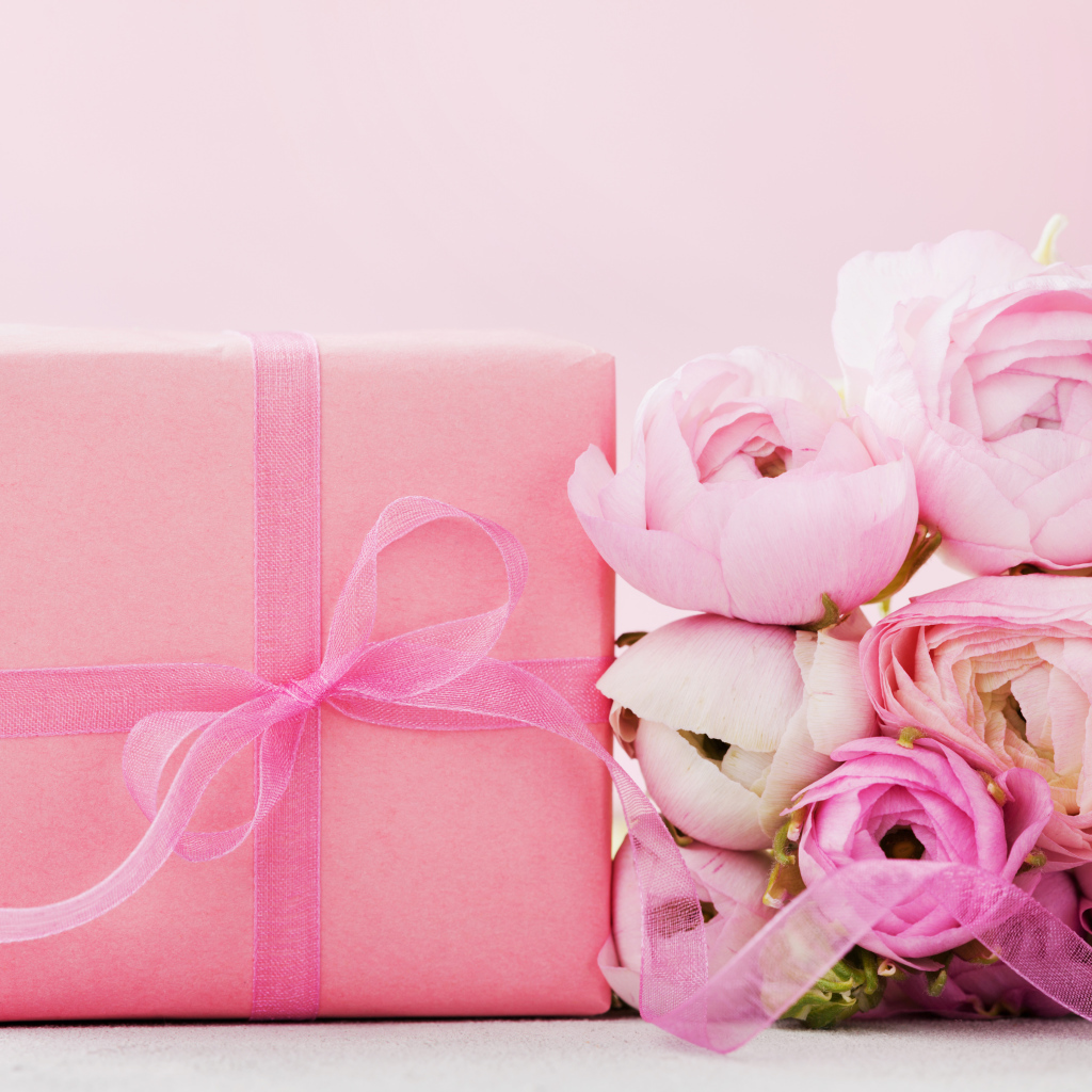 Розовый подарок с букетом розовых лютиков на розовом фоне