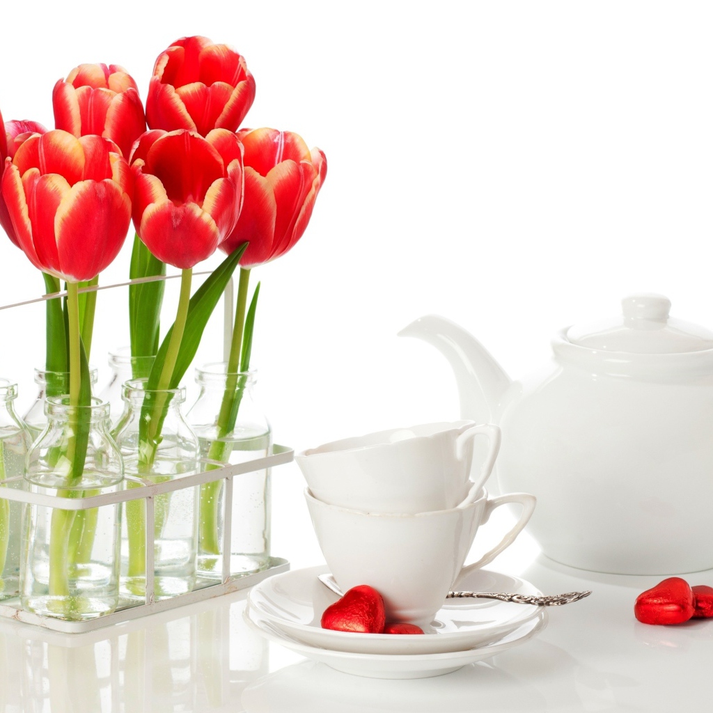 Красные тюльпаны с чайным сервизом на белом фоне