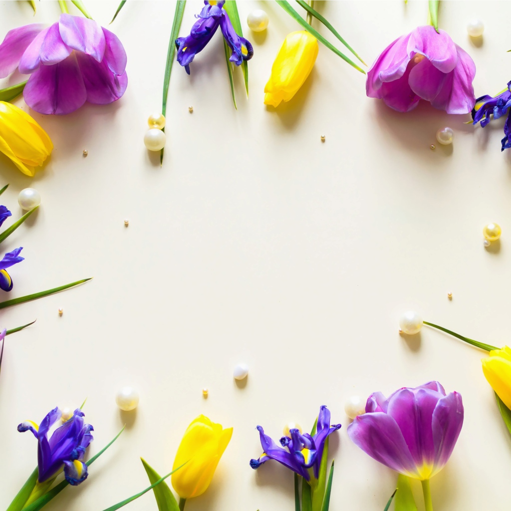 Тюльпаны  и ирисы с жемчужинами на столе 