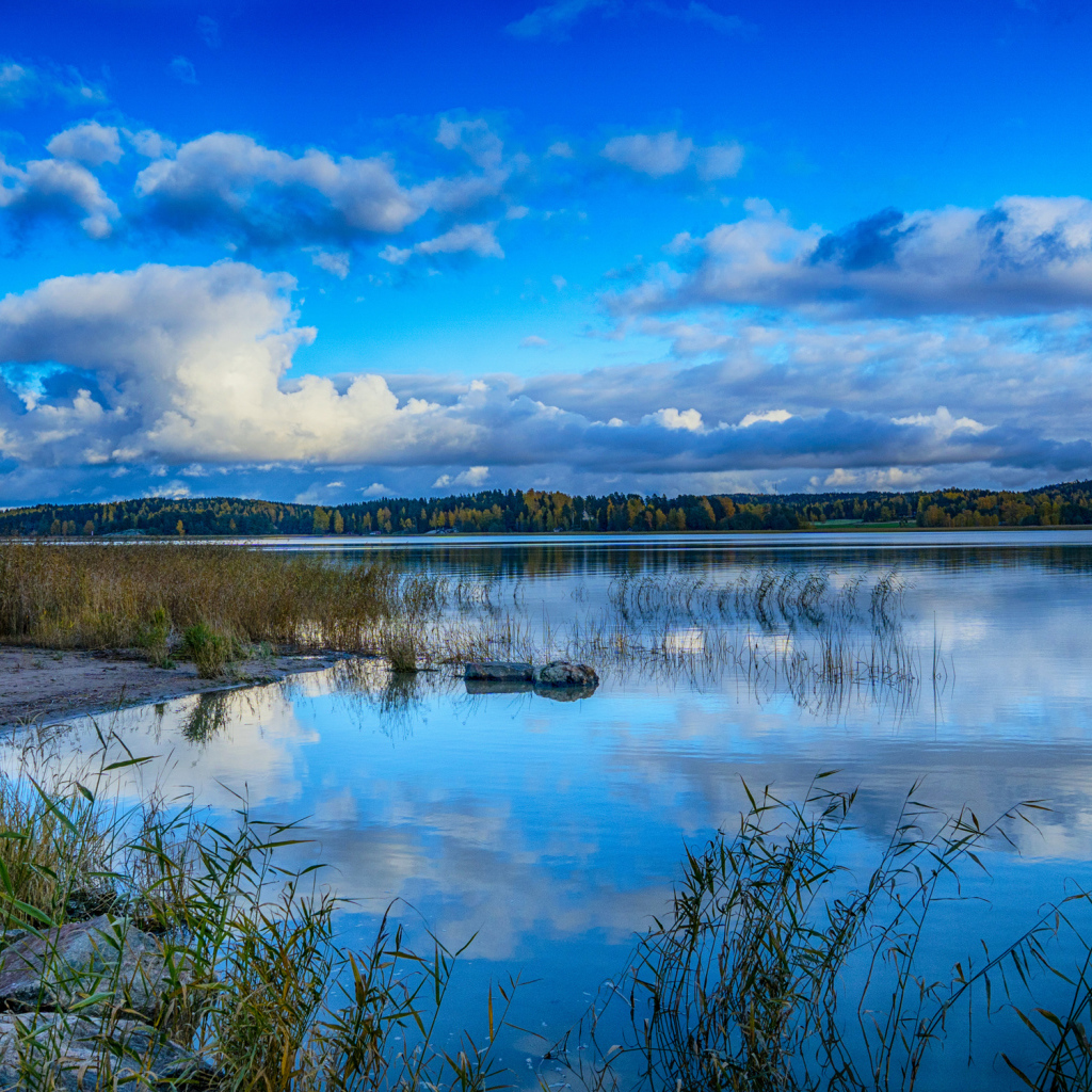Голубое небо с облаками отражается в озере