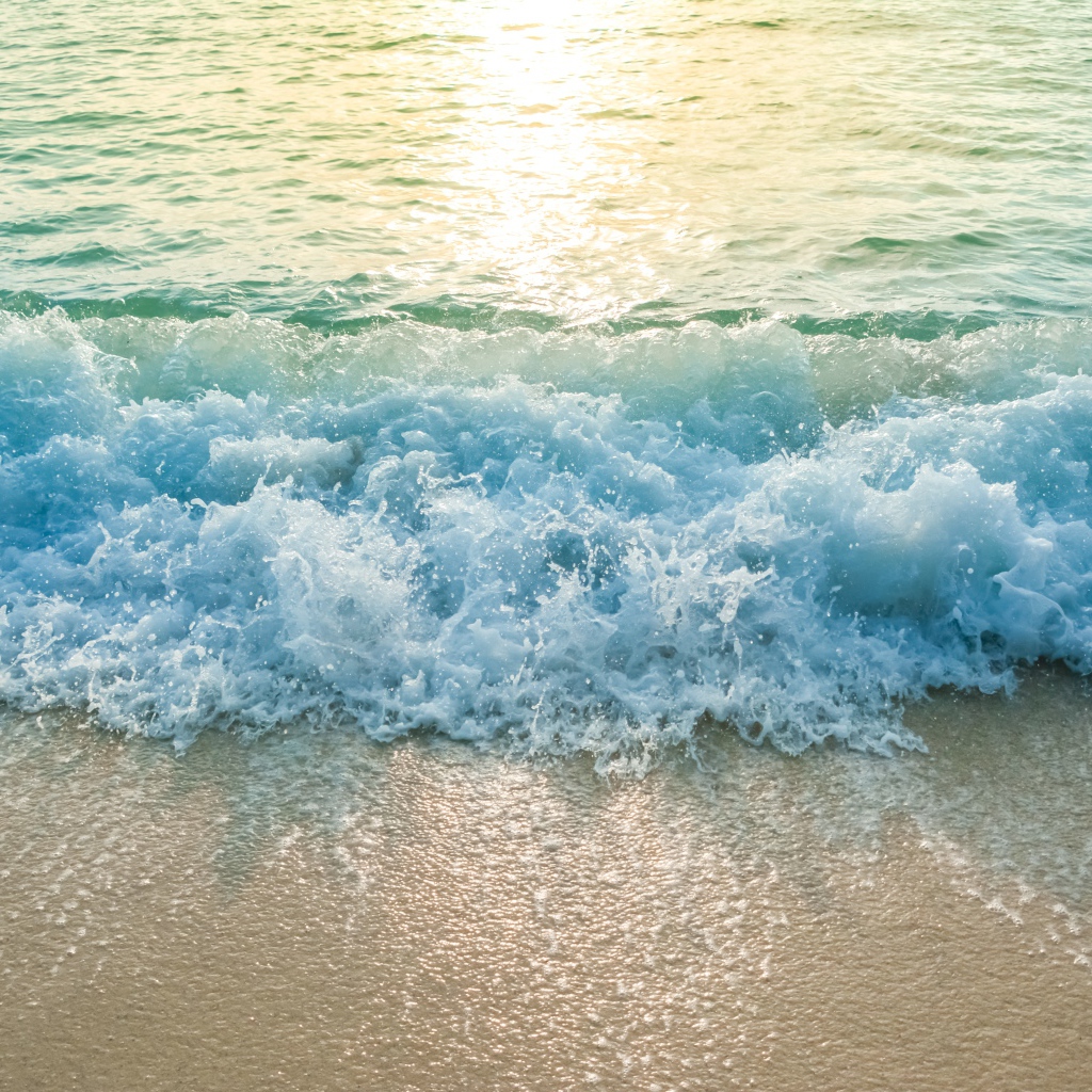 Голубая волна на желтом морском песке