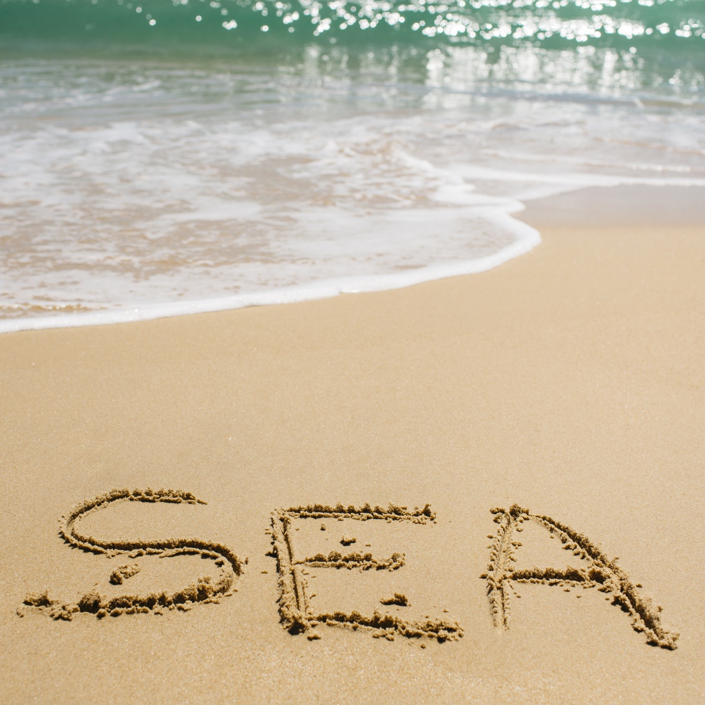 Надпись на песке у моря летом