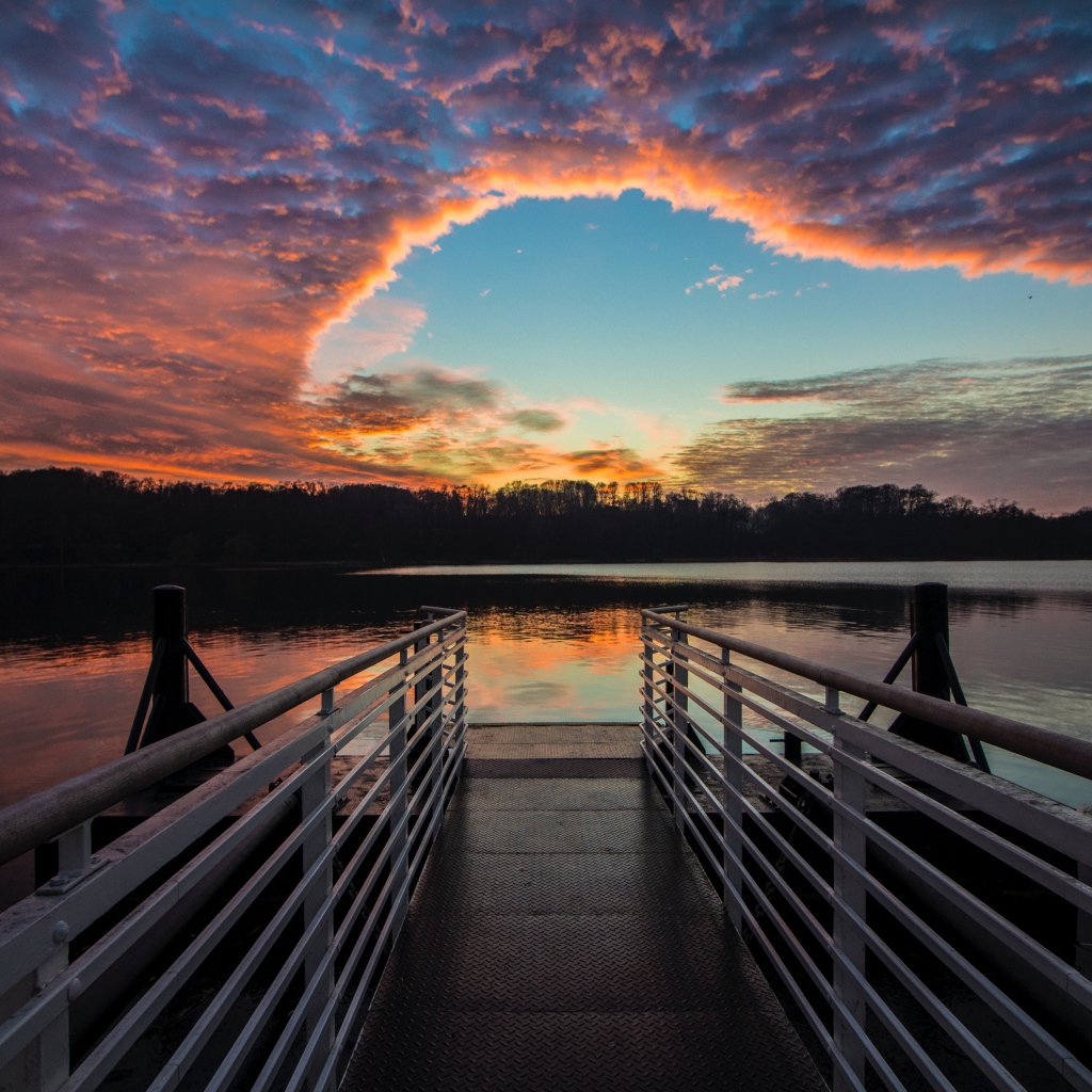 Мост на озере на фоне красивого неба на закате