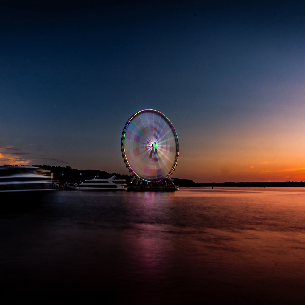 Колесо обозрения у воды на закате