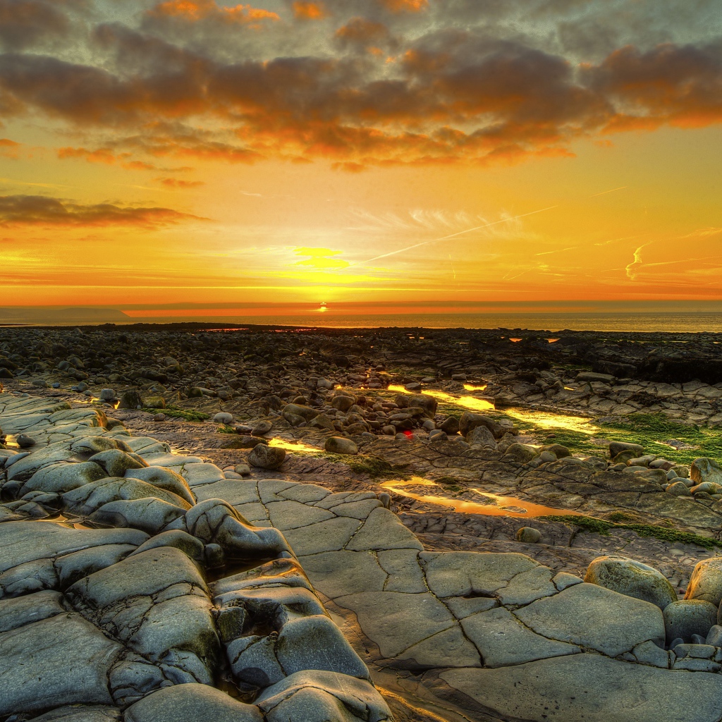 Каменный берег на фоне красивого неба на закате солнца