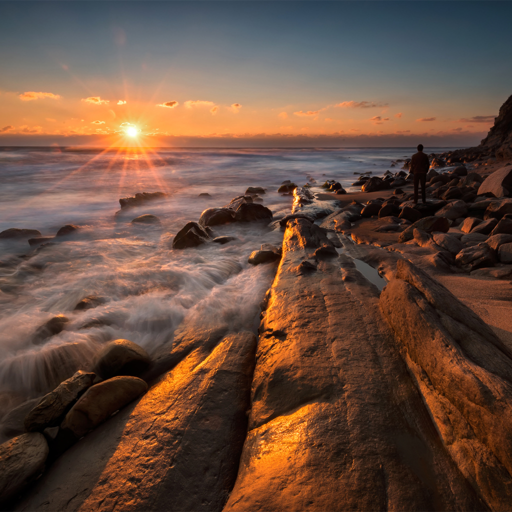 Каменный берег на морском побережье на закате солнца