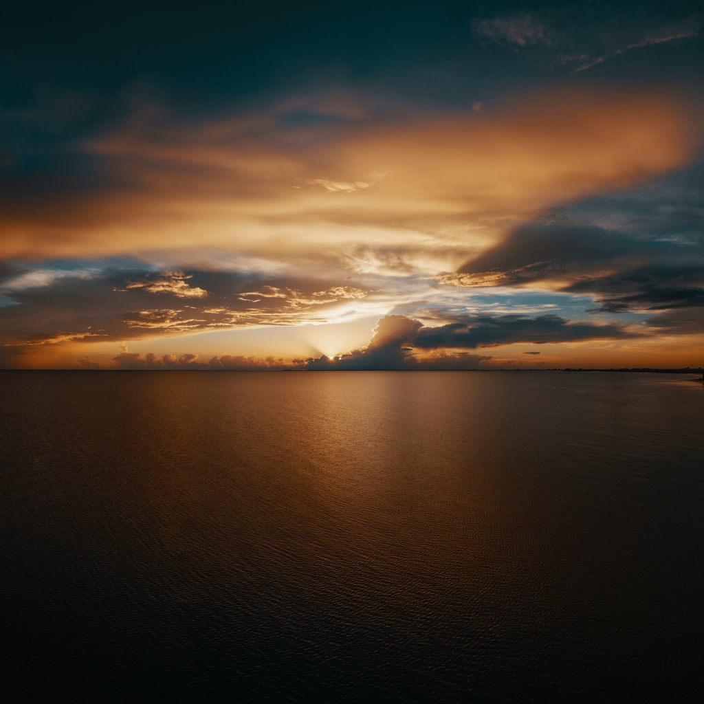 Закат солнца в красивом небе над тихой водой моря