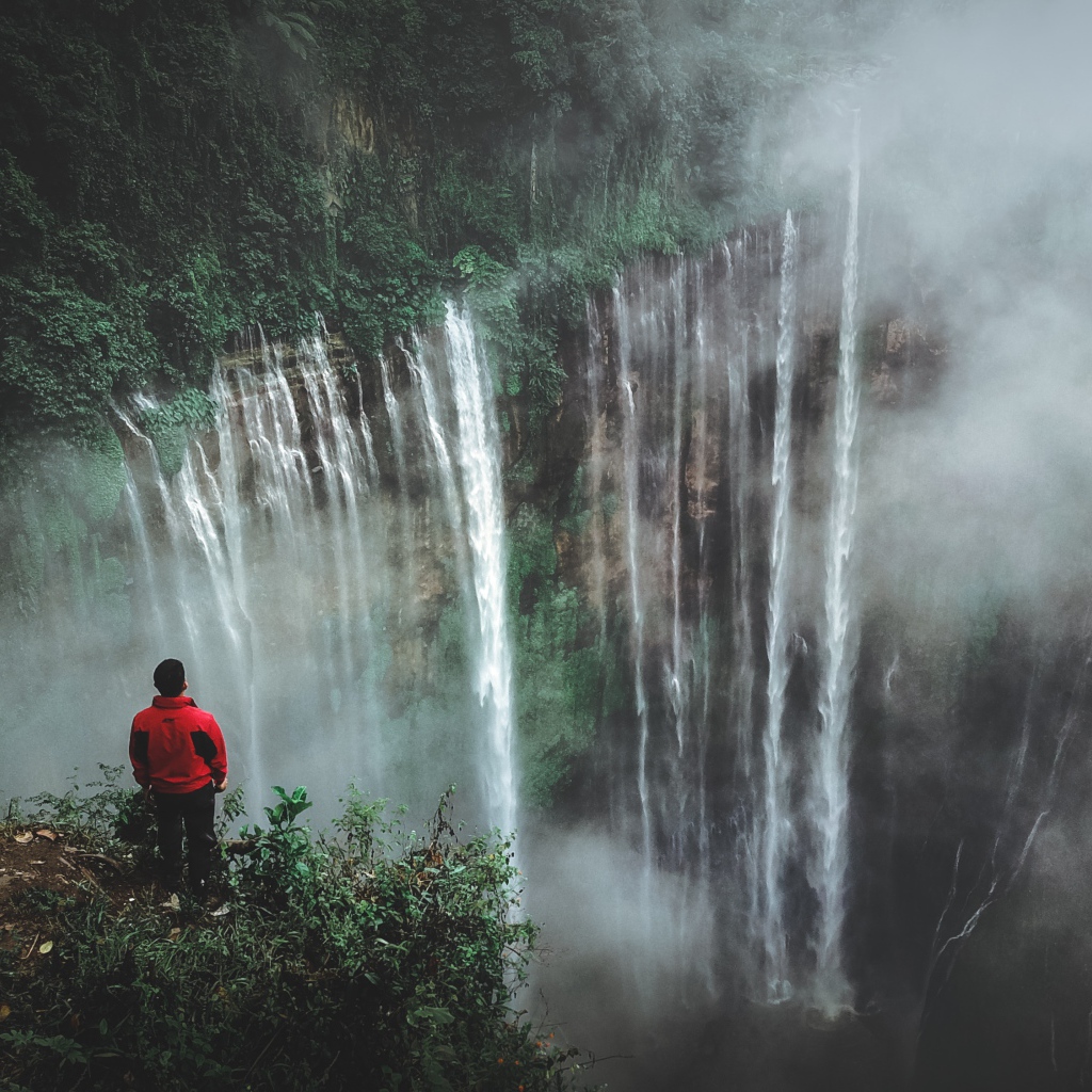 Человек смотрит на водопад сверху. 