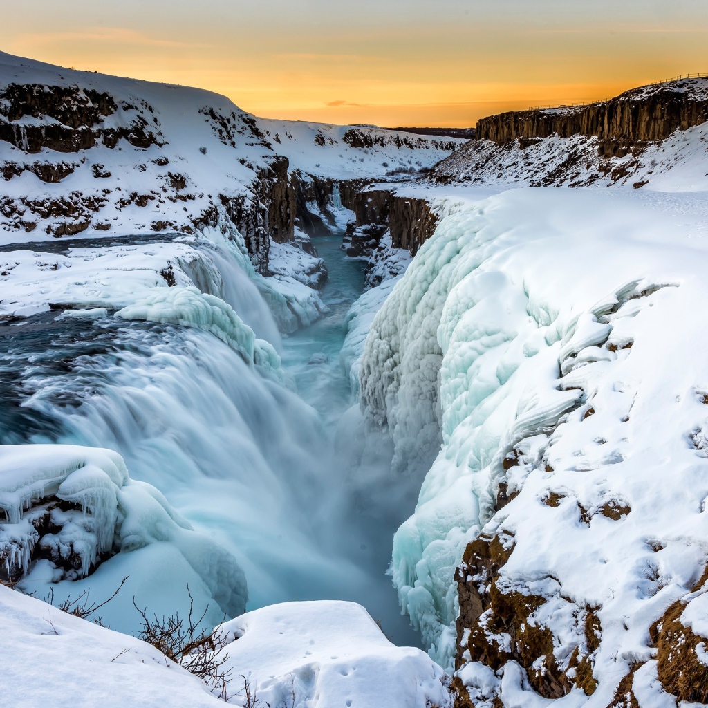 Заледеневший водопад у покрытых снегом берегов, Исландия