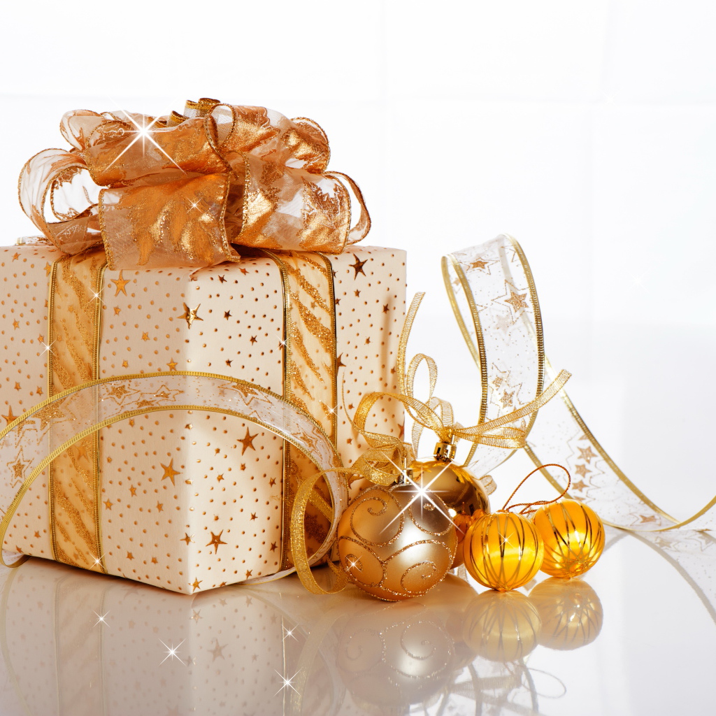 Красивый подарок с лентой и елочными шарами на белом фоне на Новый год 2019