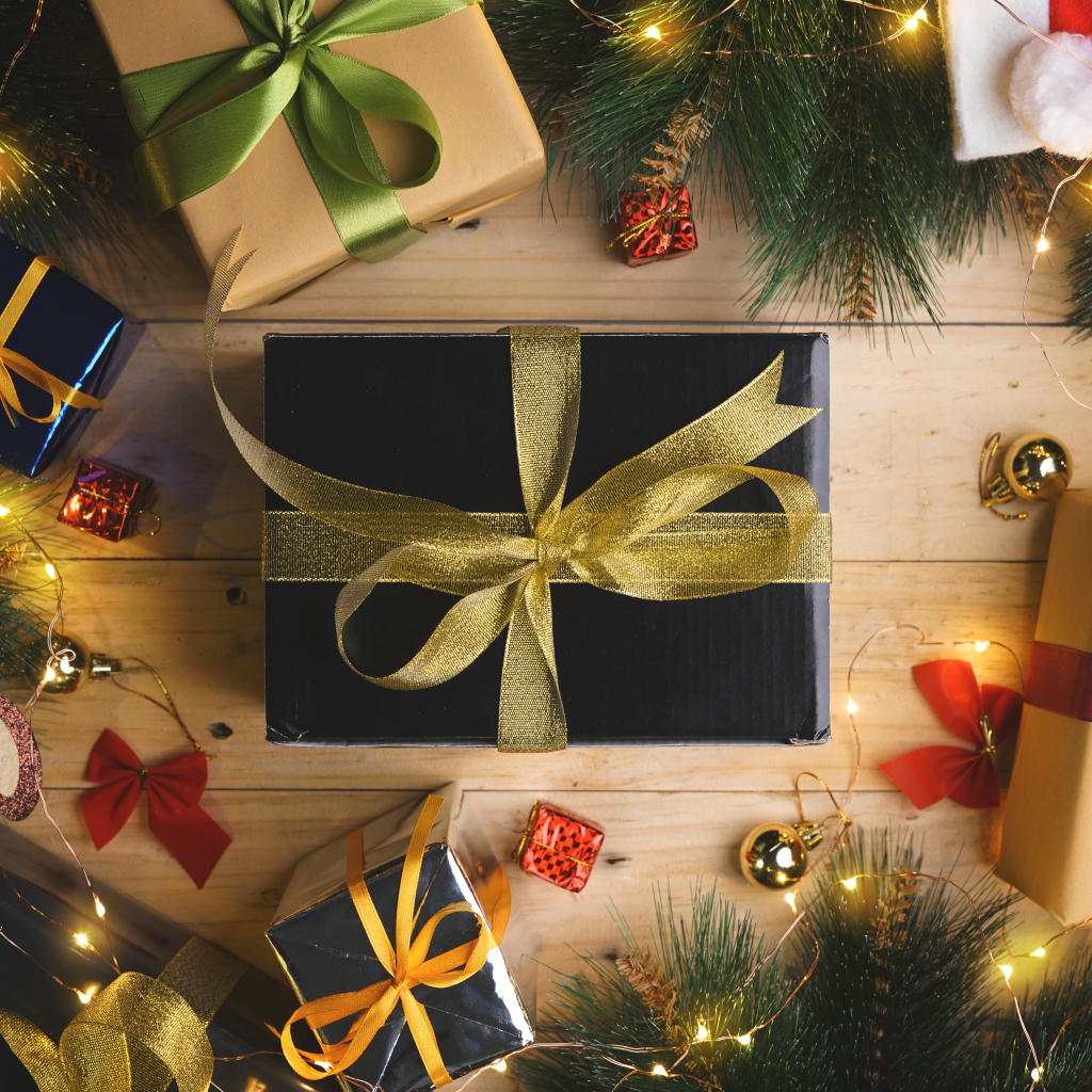 Новогодние подарки с еловыми ветками и гирляндой 