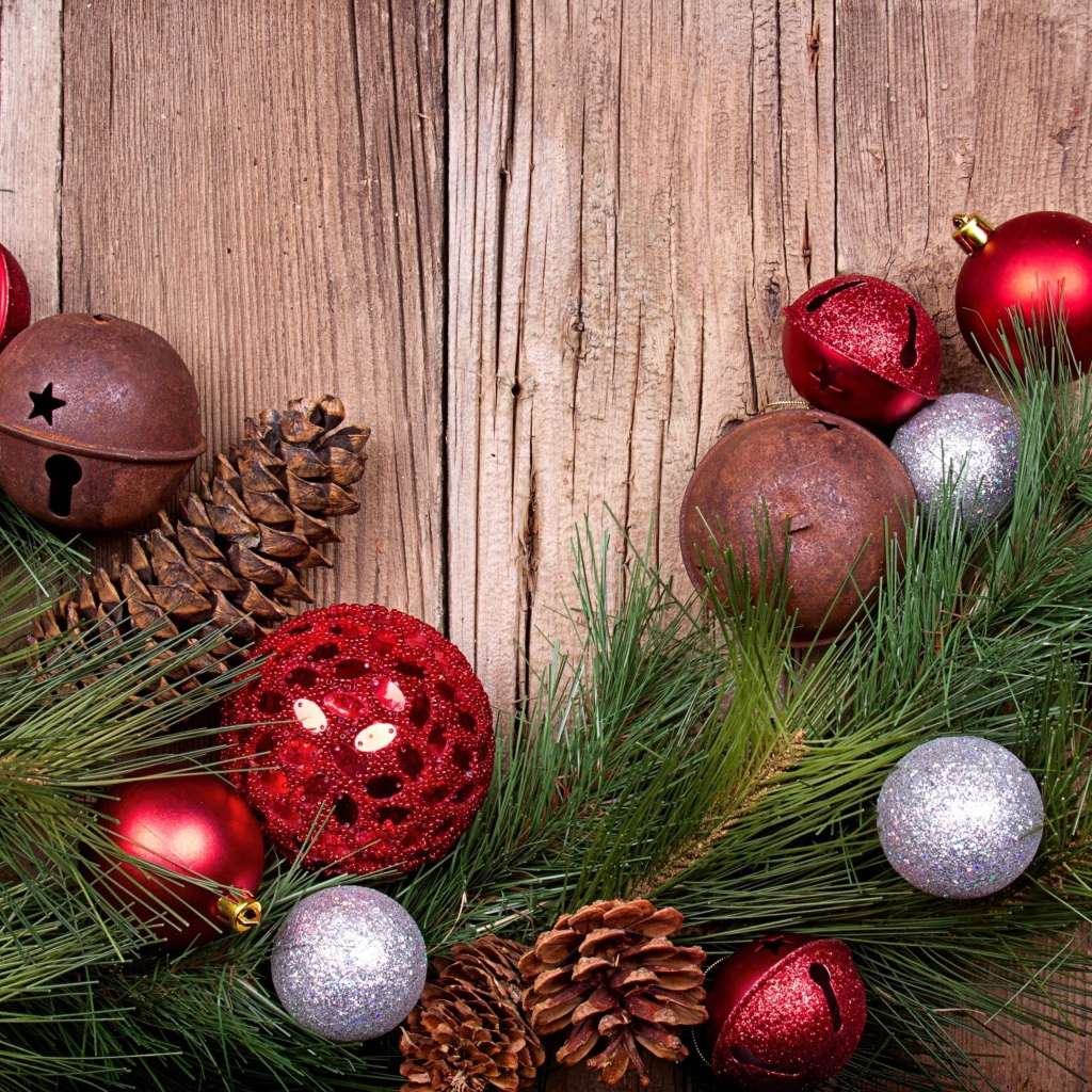 Зеленая еловая ветка с шишками и игрушками на деревянном фоне