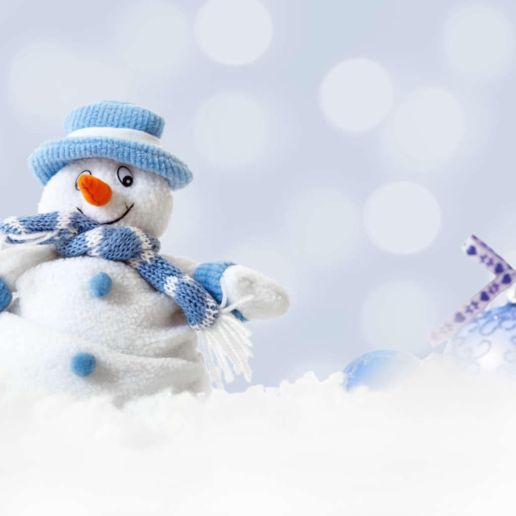 Игрушка снеговик и елочная игрушка на снегу 