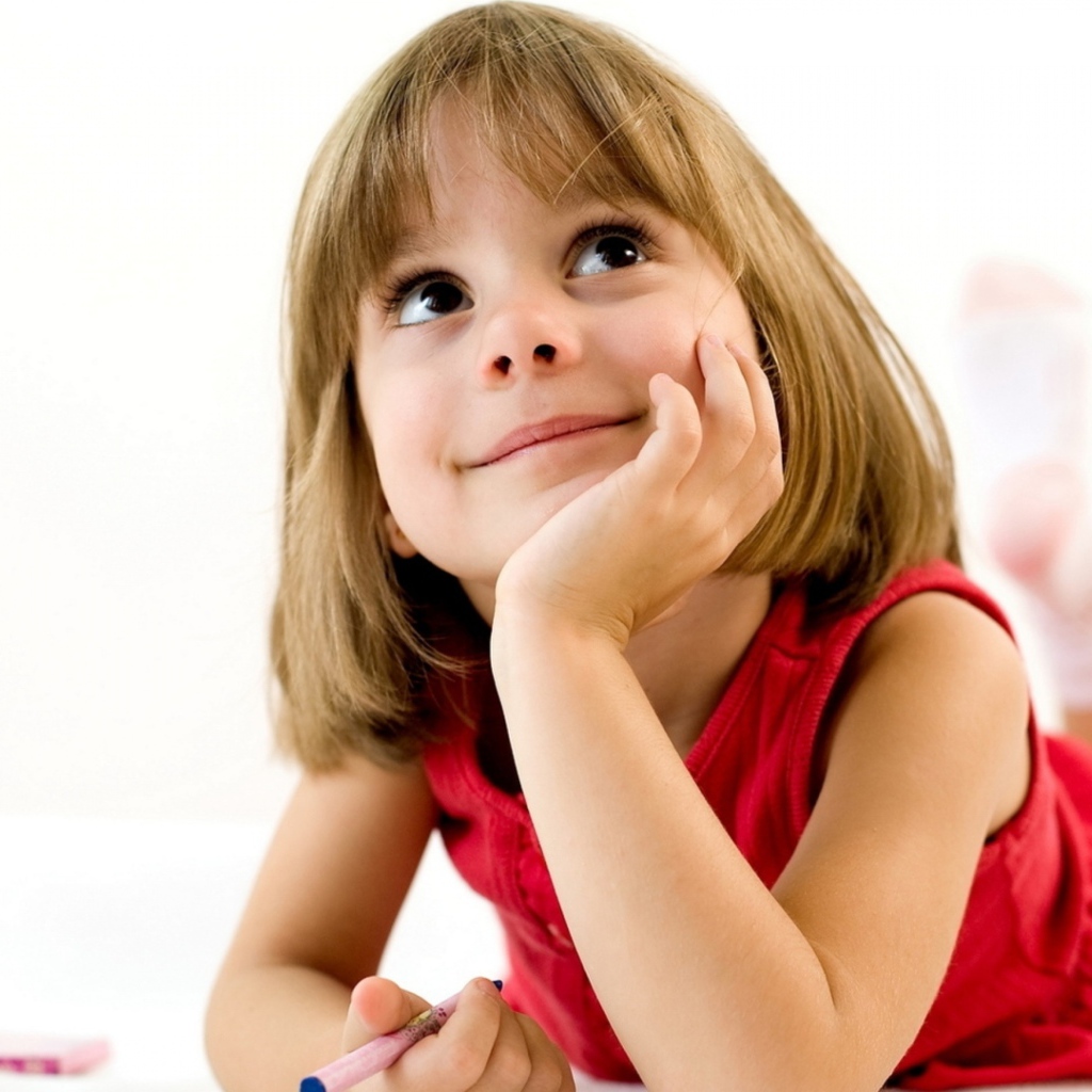 Милая девочка в красном платье рисует