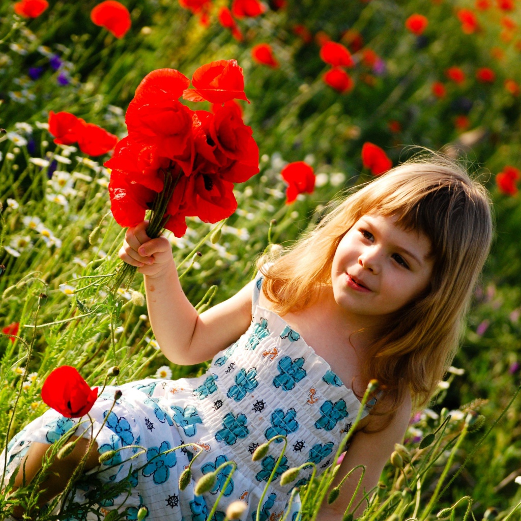 Милая маленькая девочка с букетом красных маков