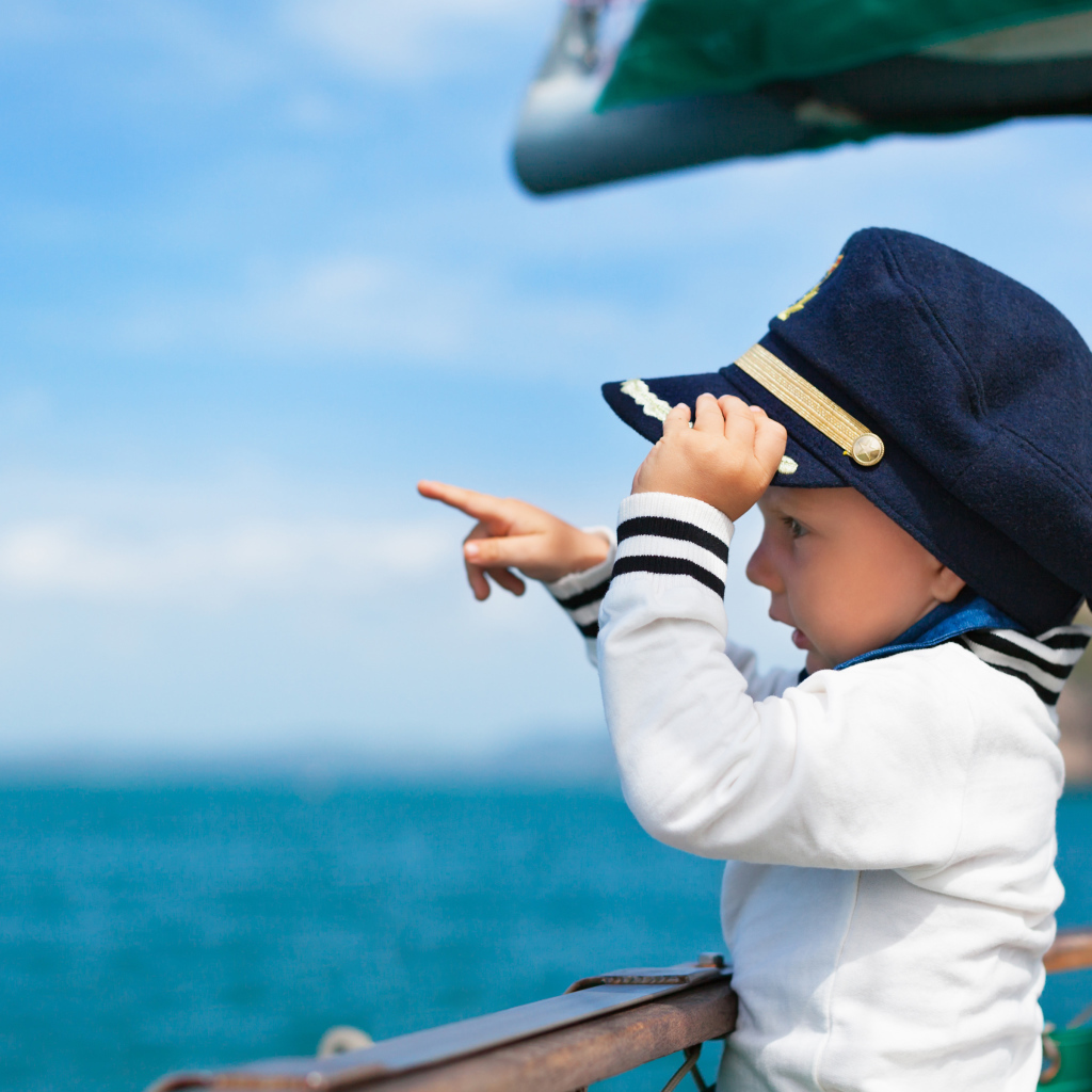 Маленький мальчик в форме капитана на корабле
