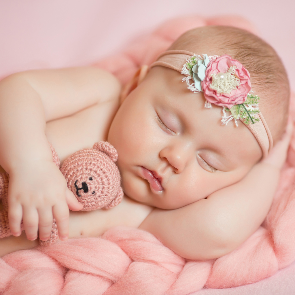 Спящая маленькая девочка с вязаным медвежонком в руке