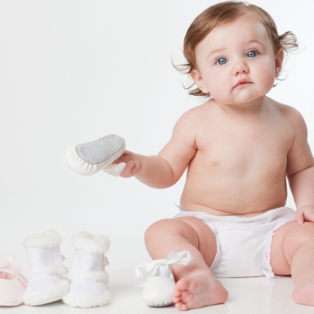 Маленький грудной ребенок с детской обувью