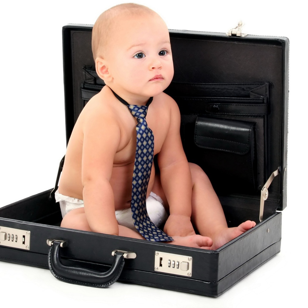 Маленький ребенок в галстуки сидит в кожаном дипломате