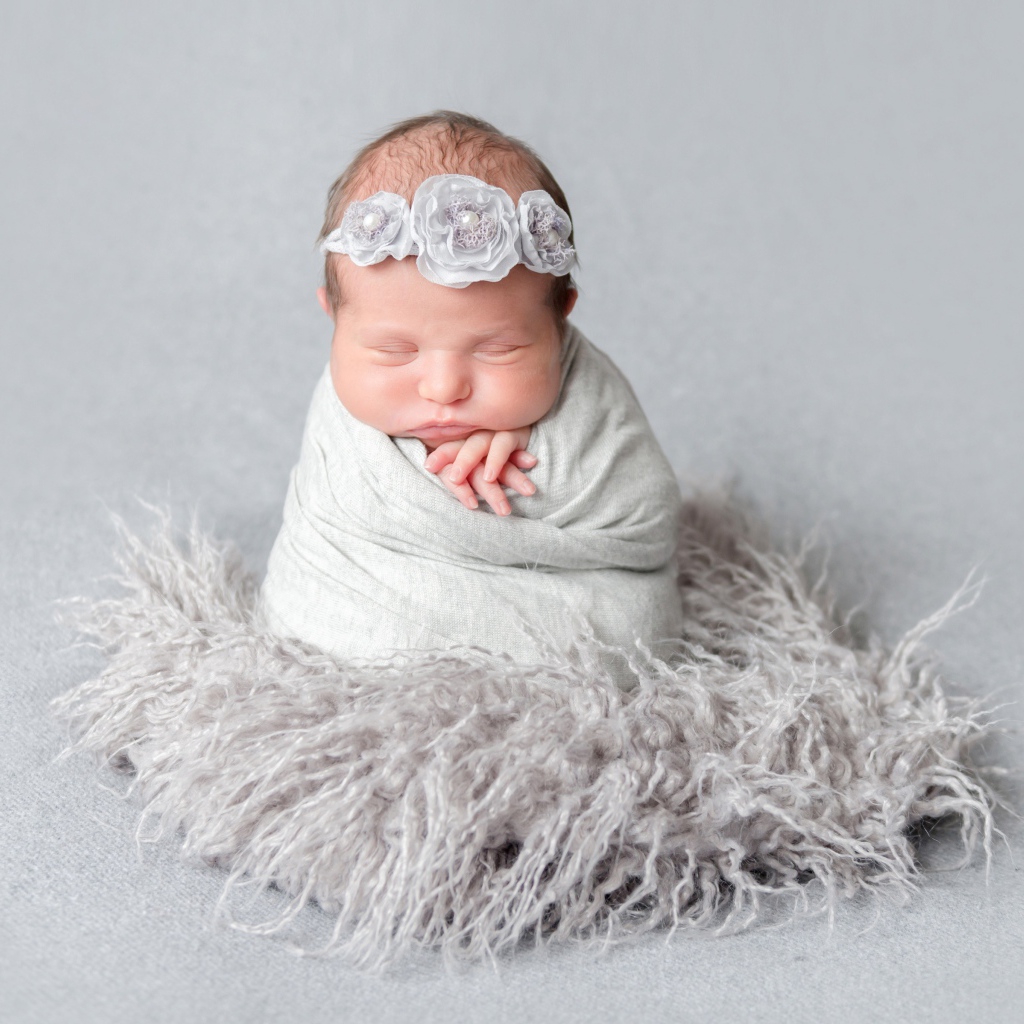 Маленький спящий младенец на сером фоне