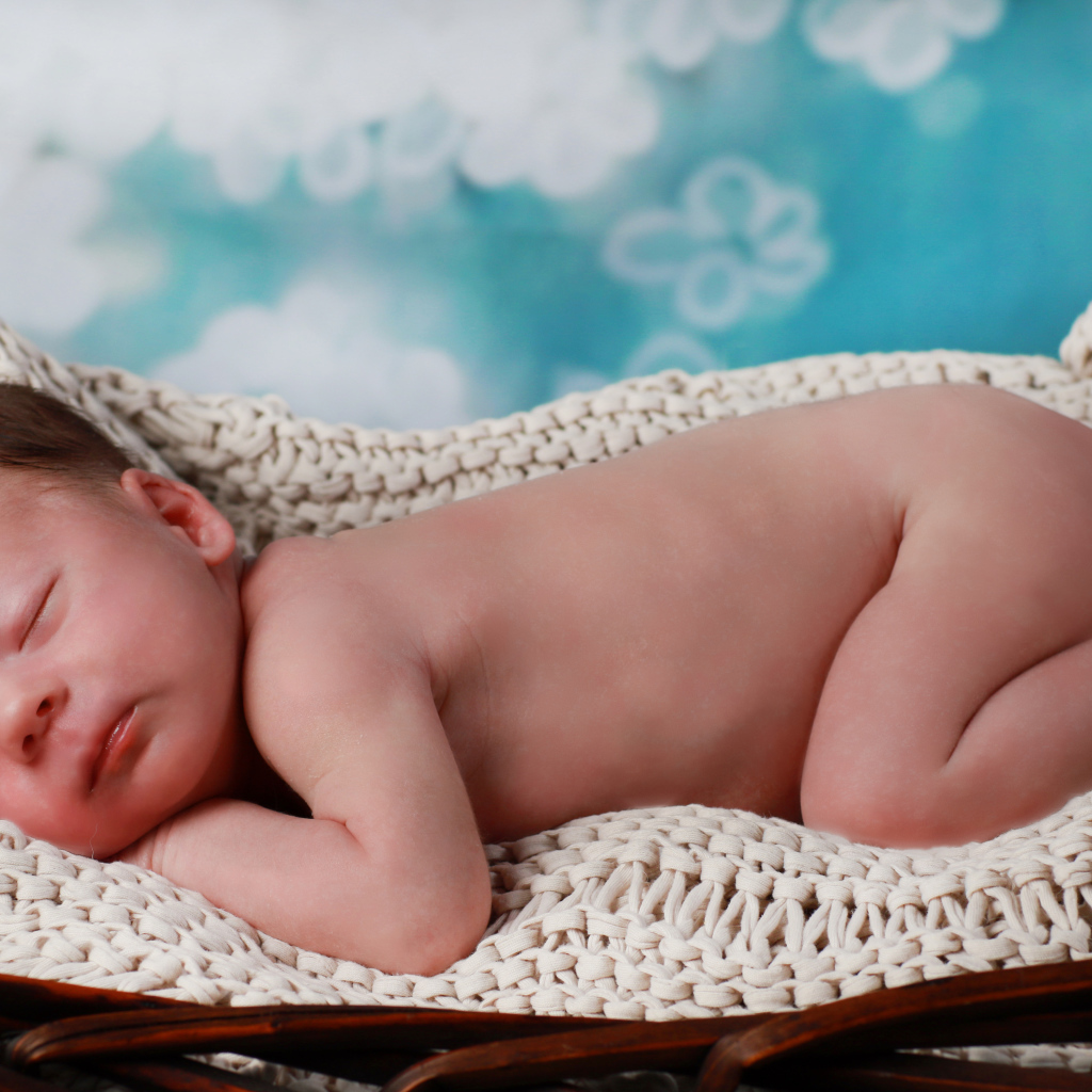 Маленький спящий грудной ребенок в колыбели