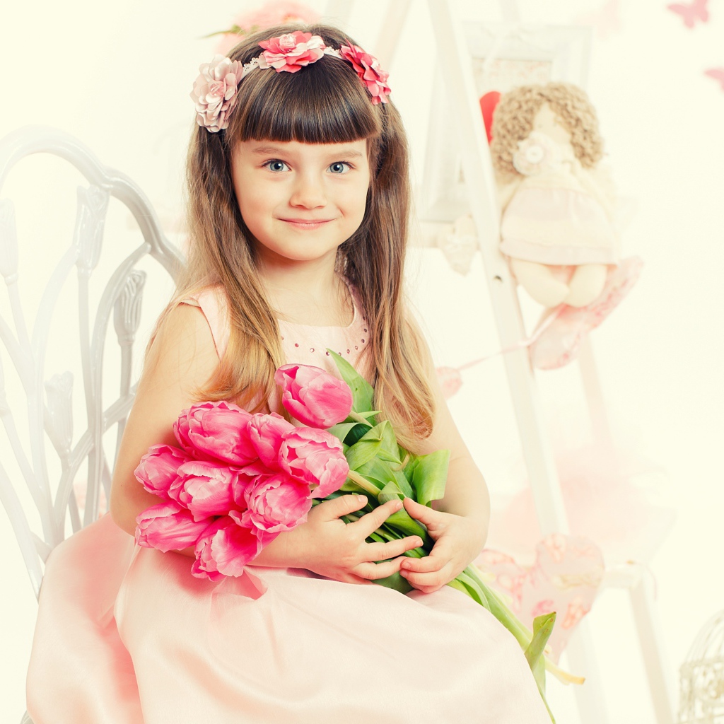Красивая милая голубоглазая девочка с букетом розовых тюльпанов