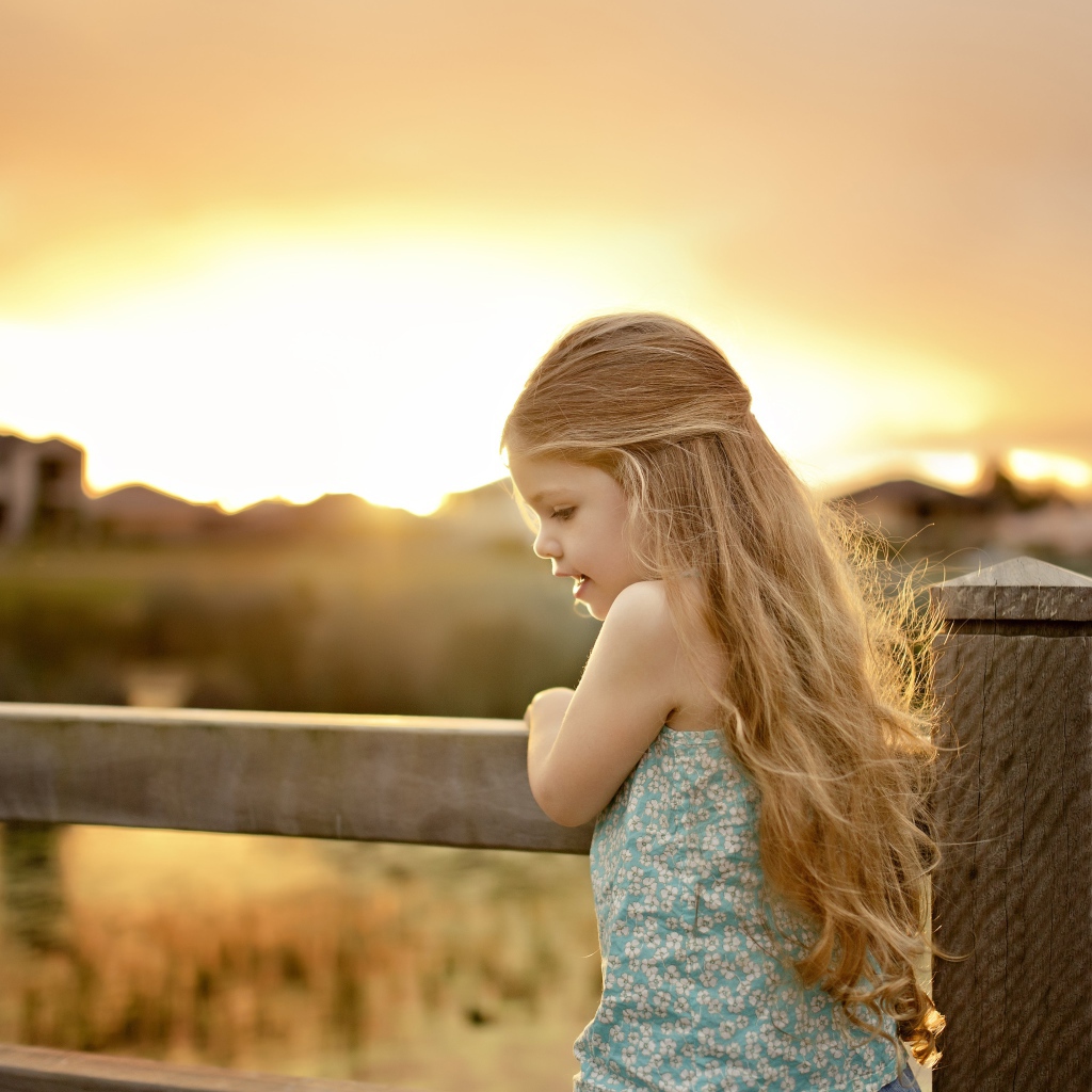 Красивая маленькая девочка на закате солнца