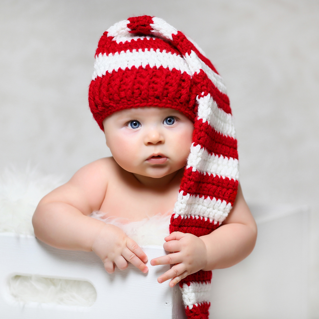 Голубоглазый младенец в длинной вязаной шапке