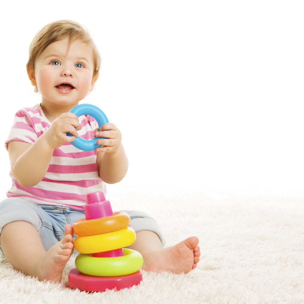 Голубоглазый маленький мальчик с игрушкой на белом фоне