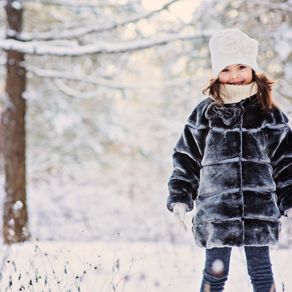 Милая маленькая девочка в шубе зимой