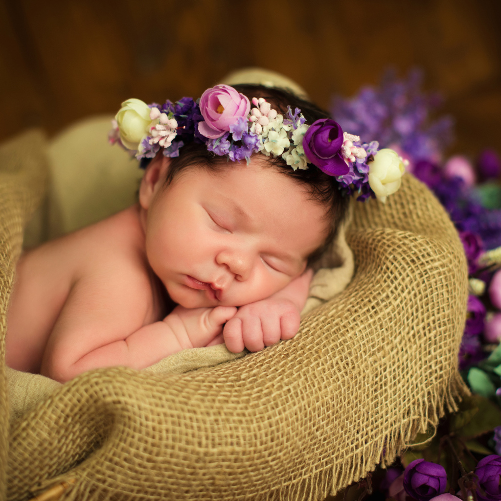 Милый спящий младенец с венком на голове