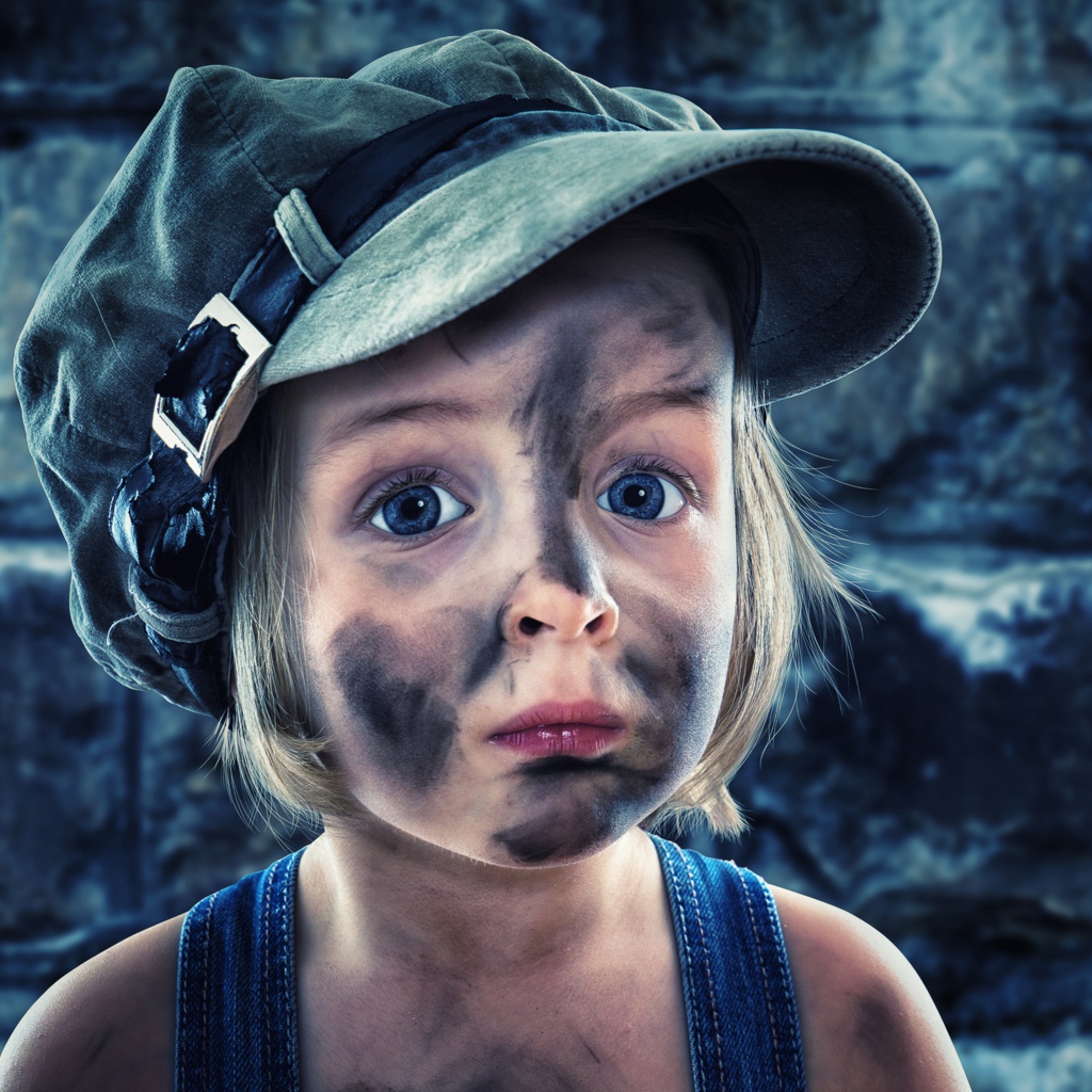 Смешная девочка в кепке с грязным лицом