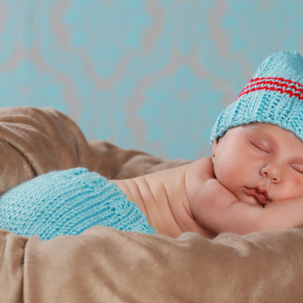 Забавный спящий младенец в голубом вязаном костюме 